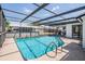 A relaxing screened-in pool with clear blue water, ladder, and ample deck space for lounging in a backyard setting at 6611 Ridge Crest Dr, Port Richey, FL 34668