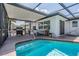 Enclosed outdoor pool area with grill and patio set, perfect for outdoor dining and entertaining near the sparkling pool at 6611 Ridge Crest Dr, Port Richey, FL 34668