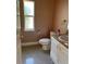 Compact bathroom featuring a toilet, sink, vanity, and a window providing natural light at 7144 Gulf Breeze Cir, Hudson, FL 34667
