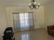 Inviting living room featuring tile flooring, crown molding, natural light, and a modern chandelier at 7144 Gulf Breeze Cir, Hudson, FL 34667