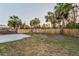 Spacious backyard features a wooden fence, mature palm trees, and a swing set, perfect for outdoor enjoyment at 7235 Astor Dr, New Port Richey, FL 34652