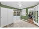 Bedroom with soft carpet, sliding glass doors to the outside, and bright green walls at 7235 Astor Dr, New Port Richey, FL 34652