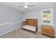 Bright bedroom with soft carpet, a ceiling fan, and a rustic style baby bed at 7235 Astor Dr, New Port Richey, FL 34652
