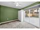 Cozy bedroom featuring new carpet, a ceiling fan, a sliding door, and backyard access at 7235 Astor Dr, New Port Richey, FL 34652