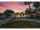 Cozy home with a well-maintained front yard, driveway, and colorful sky at dusk at 7235 Astor Dr, New Port Richey, FL 34652