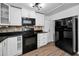 Updated kitchen featuring black appliances, white cabinetry, and modern lighting fixtures at 7235 Astor Dr, New Port Richey, FL 34652