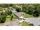 Aerial view of a single-Gathering home featuring a circular driveway, a three-car garage, and mature landscaping at 7495 Birdland Cres, Spring Hill, FL 34607