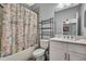 Hall bathroom with shower-tub combo, large mirror and granite vanity at 7495 Birdland Cres, Spring Hill, FL 34607