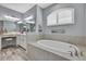 Bright bathroom featuring a soaking tub, a makeup vanity, and modern fixtures at 7495 Birdland Cres, Spring Hill, FL 34607