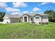 Charming single-story home boasts lush green lawn and inviting entrance with well-maintained landscaping at 7495 Birdland Cres, Spring Hill, FL 34607