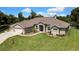 Beautiful one-story home with well-kept lawn, neutral paint, manicured landscaping and an arched entryway at 7495 Birdland Cres, Spring Hill, FL 34607