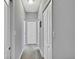 A well-lit hallway with multiple white doors offers access to different areas of the home at 7495 Birdland Cres, Spring Hill, FL 34607