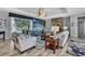 Spacious living room features elegant furnishings, a decorative stone fireplace, and a beachy mural at 7495 Birdland Cres, Spring Hill, FL 34607