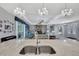 Open-concept living room with a stone fireplace, high ceilings, and view from kitchen at 7495 Birdland Cres, Spring Hill, FL 34607