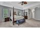 Large main bedroom featuring a four-poster bed, tray ceiling, and neutral decor at 7495 Birdland Cres, Spring Hill, FL 34607