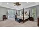Spacious main bedroom with a four-poster bed, tray ceiling, and plenty of natural light at 7495 Birdland Cres, Spring Hill, FL 34607