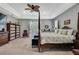 This primary bedroom boasts a four-poster bed, tray ceiling, and neutral walls and carpet at 7495 Birdland Cres, Spring Hill, FL 34607