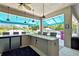 Entertain outdoors with a built-in kitchen with stainless steel appliances, granite countertops, and a shaded dining area at 7495 Birdland Cres, Spring Hill, FL 34607