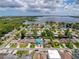 Stunning aerial view of a waterfront community with many homes, canals, and a community pool at 75 N Canal Dr, Palm Harbor, FL 34684