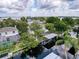 Expansive aerial view of a lakeside home featuring a pool, boat lift, and manicured grounds, highlighting waterfront living at 75 N Canal Dr, Palm Harbor, FL 34684