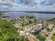 Aerial view of waterfront homes, docks, and canals near a large lake, surrounded by lush green trees at 75 N Canal Dr, Palm Harbor, FL 34684