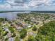 A broad aerial view of waterfront homes, docks, and canals by a lake, with surrounding lush trees at 75 N Canal Dr, Palm Harbor, FL 34684