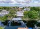 Aerial perspective displays the home with a boat lift and covered patio, all beautifully situated on the waterfront at 75 N Canal Dr, Palm Harbor, FL 34684