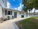 Home back exterior featuring a clean patio, blue doors, and green chairs, showcasing the house's tidy outdoor space at 75 N Canal Dr, Palm Harbor, FL 34684