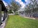 Well-maintained backyard with a pergola-covered patio, lush lawn, and a view of the canal at 75 N Canal Dr, Palm Harbor, FL 34684