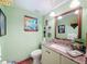 Charming half bathroom featuring granite countertop, decorative window, and stylish fixtures at 75 N Canal Dr, Palm Harbor, FL 34684