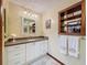 Bathroom featuring granite countertops, white cabinets, and a decorative wall shelf at 75 N Canal Dr, Palm Harbor, FL 34684