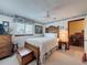 Cozy bedroom with a wooden bedframe, soft white bedding, and adjacent hallway lined with framed photos at 75 N Canal Dr, Palm Harbor, FL 34684