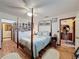 Bedroom with four-poster bed, hardwood floors, and plenty of wall decorations at 75 N Canal Dr, Palm Harbor, FL 34684