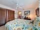 Cozy bedroom featuring a patterned bedspread, wooden closet doors, and comfortable furnishings at 75 N Canal Dr, Palm Harbor, FL 34684