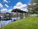 A picturesque boat lift nestled along the canal, framed by vibrant greenery and clear skies, perfect for waterfront living at 75 N Canal Dr, Palm Harbor, FL 34684