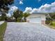 A paved driveway leads to a two-car garage with a white door and brick accents on a sunny day at 75 N Canal Dr, Palm Harbor, FL 34684
