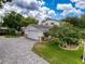 View of detached garage with a brick-paved driveway and well-maintained garden in a charming home at 75 N Canal Dr, Palm Harbor, FL 34684