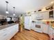 Open-concept kitchen with white cabinets, granite countertops, and hardwood floors at 75 N Canal Dr, Palm Harbor, FL 34684