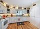 Bright kitchen with white cabinets, granite countertops, and hardwood floors at 75 N Canal Dr, Palm Harbor, FL 34684