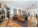Cozy living room featuring hardwood floors, a fireplace, comfortable seating, and a view into the kitchen at 75 N Canal Dr, Palm Harbor, FL 34684