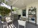 Cozy outdoor dining area with built-in grill and comfortable seating under a covered patio at 75 N Canal Dr, Palm Harbor, FL 34684