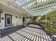 Outdoor backyard patio space with pergola, seating area, and gray wooden floors at 75 N Canal Dr, Palm Harbor, FL 34684