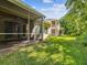 Lush backyard showcasing the screened-in patio, well-maintained lawn, and neighboring properties at 7616 Wimpole Dr, New Port Richey, FL 34655