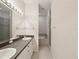 Bathroom featuring a double sink vanity with large mirror, tile flooring, bathtub, and walk-in shower at 7616 Wimpole Dr, New Port Richey, FL 34655