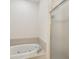 Close-up of the tiled bathtub with a shower beside it and shower door at 7616 Wimpole Dr, New Port Richey, FL 34655