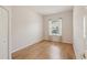 Bedroom showcasing hardwood floors, baseboard trim, and window at 7616 Wimpole Dr, New Port Richey, FL 34655
