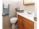 Bright bathroom featuring a wood vanity, a white toilet, and tiled flooring at 7715 Gulf Highlands Dr, Port Richey, FL 34668