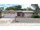 Charming single-story home features a two-car garage and low-maintenance landscaping in the front yard at 7715 Gulf Highlands Dr, Port Richey, FL 34668