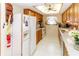 Functional kitchen with oak cabinets, white appliances, and ample countertop space at 7715 Gulf Highlands Dr, Port Richey, FL 34668