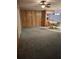 Comfortable carpeted living room with wood paneling and views into dining area at 7715 Gulf Highlands Dr, Port Richey, FL 34668